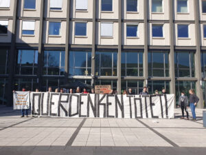 Solikundgebung vor dem Amtsgericht Koblenz mit einem großen Transparent mit der Aufschrift 'Querdenken tötet'